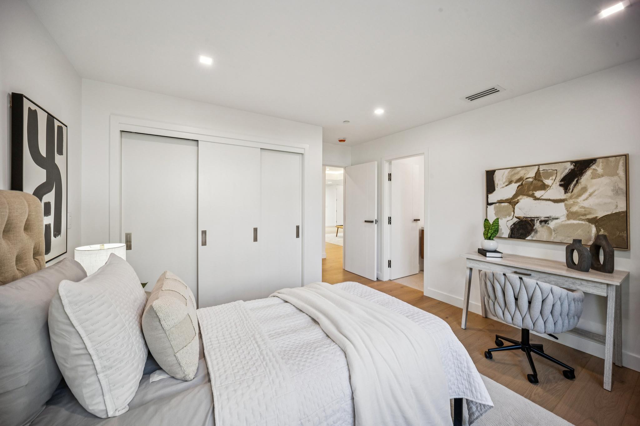 High-end guest bedroom interior in a Willow Glen custom home, featuring clean architectural lines, seamless sliding closet doors, and premium floor transitions executed by Ritz Builders.