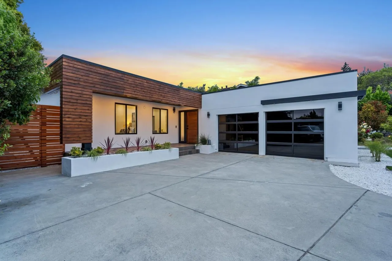 Modern front elevation of a Cupertino residence featuring warm wood siding and contemporary garage design by Ritz Builders.