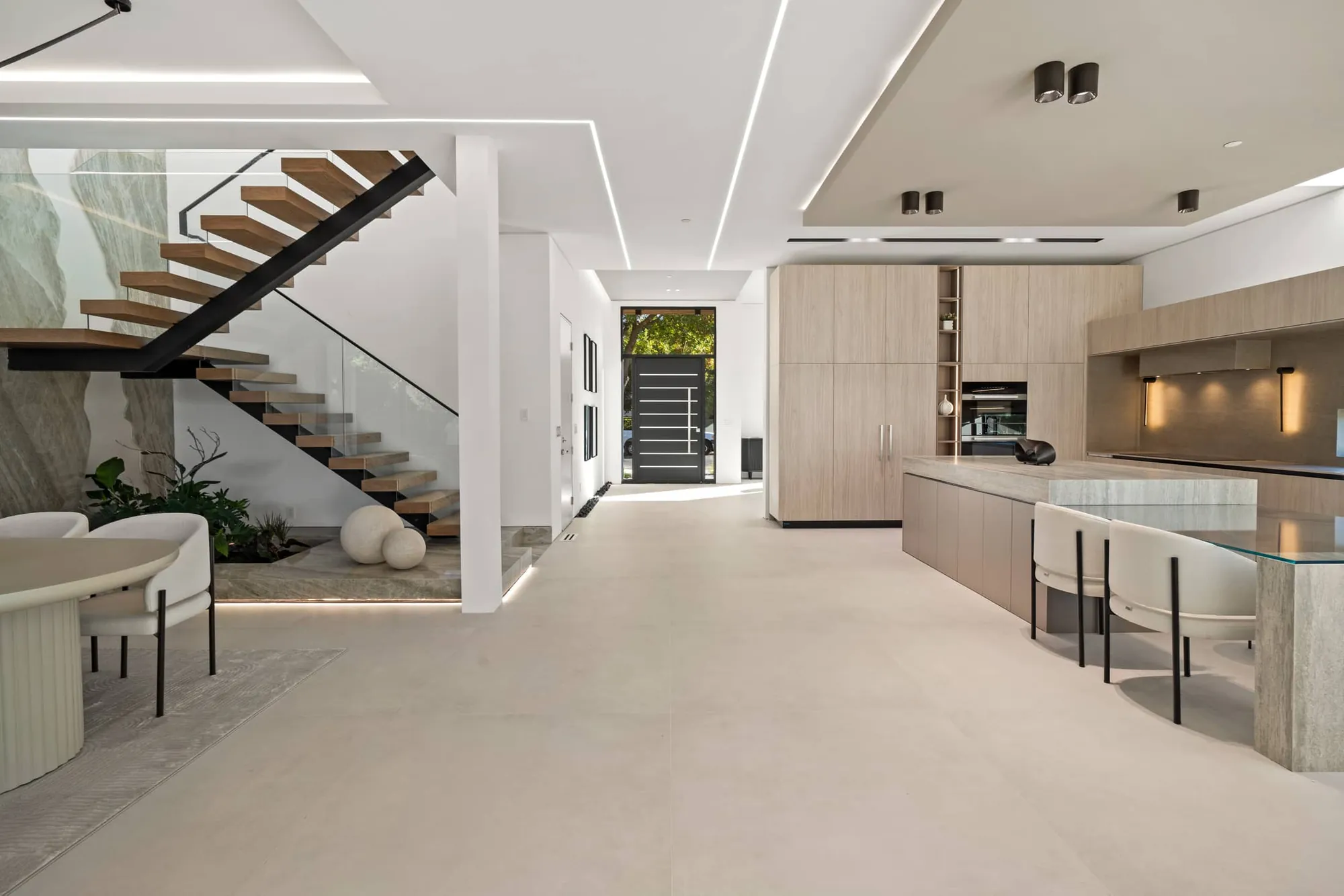 Open floor plan of the award-winning Rivera Residence in Cupertino, featuring a sculptural floating staircase and integrated kitchen by Ritz Builders.